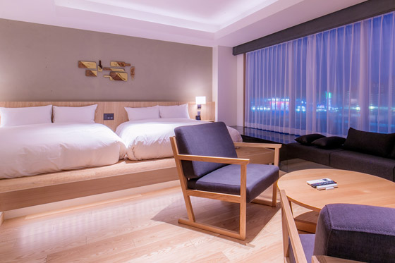 窓から夜景がのぞくデラックススイートルームの写真