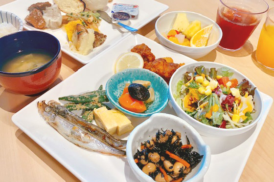 サラダや魚、煮物などさまざまな料理が一緒にお皿に盛りつけられている写真