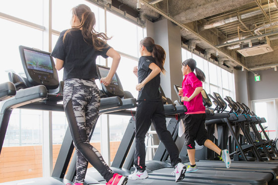 ランニングマシンで有酸素運動をする人の写真