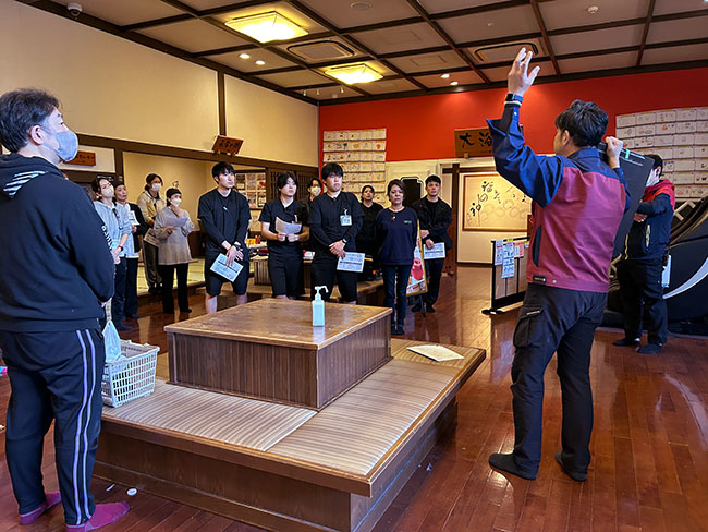 消防訓練の説明を受けている場面