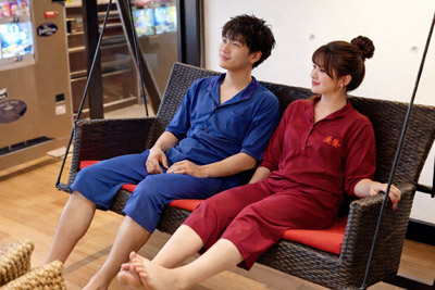 岩盤浴の休憩スペースにあるブランコでくつろぐ男女