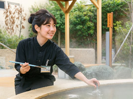 露天風呂の水質検査をする女性スタッフ
